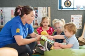 Childcare teacher reading to toddler students at New Horizon Academy