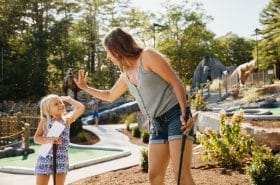 Child and mother mini golfing